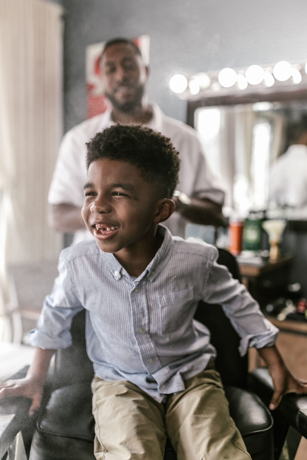 Joyful barbershop haircut hairstyle shown on a boy under 12.