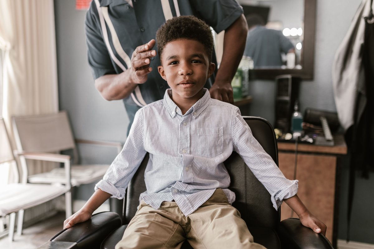 Neat pre-cut smile hairstyle shown on a boy under 12.