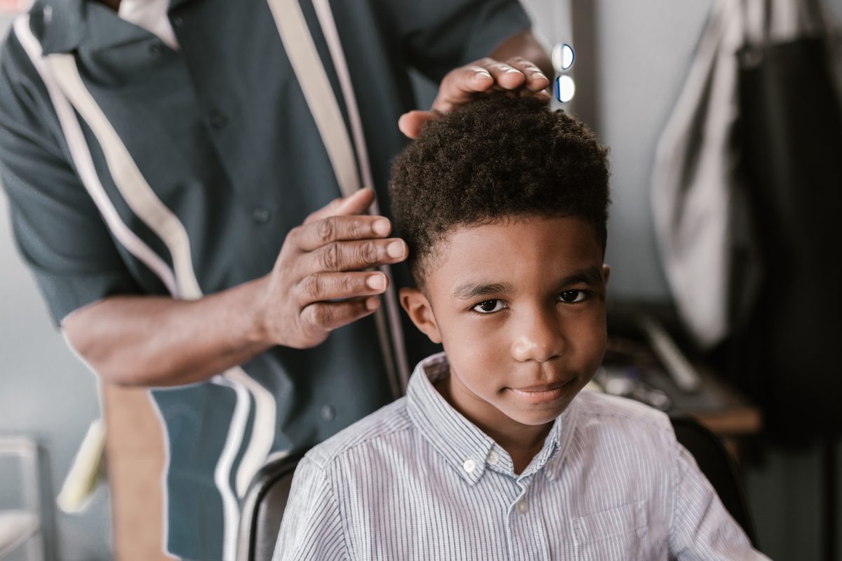 Adorable curly cut hairstyle shown on a boy under 12.