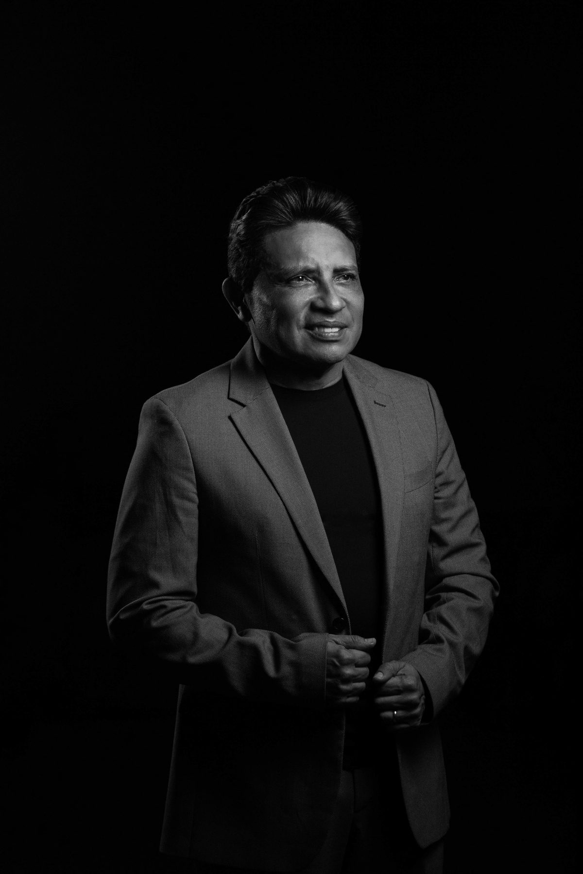 Black background suit hairstyle shown on a professional man.