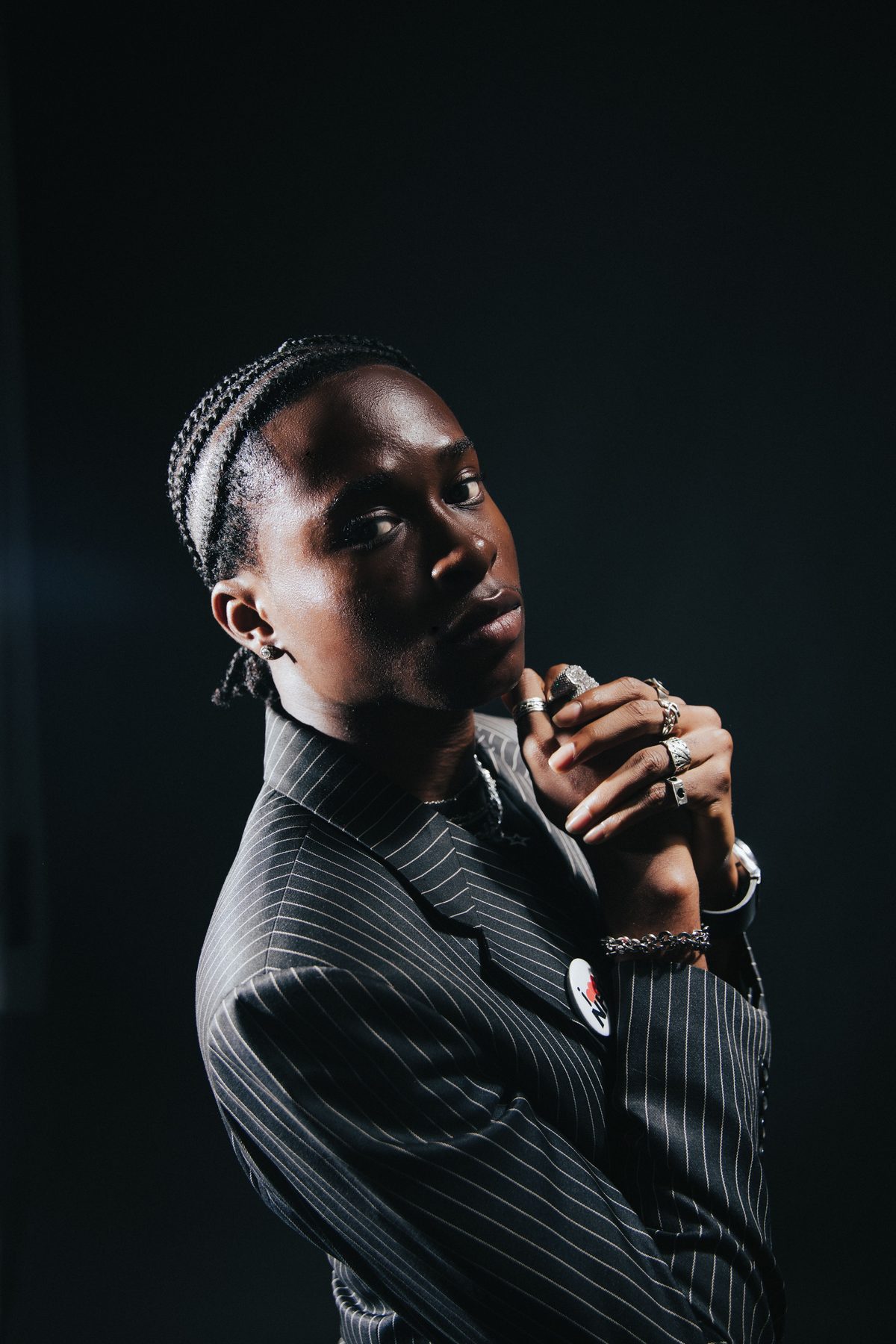 Braids and pinstripes hairstyle shown on a young man.