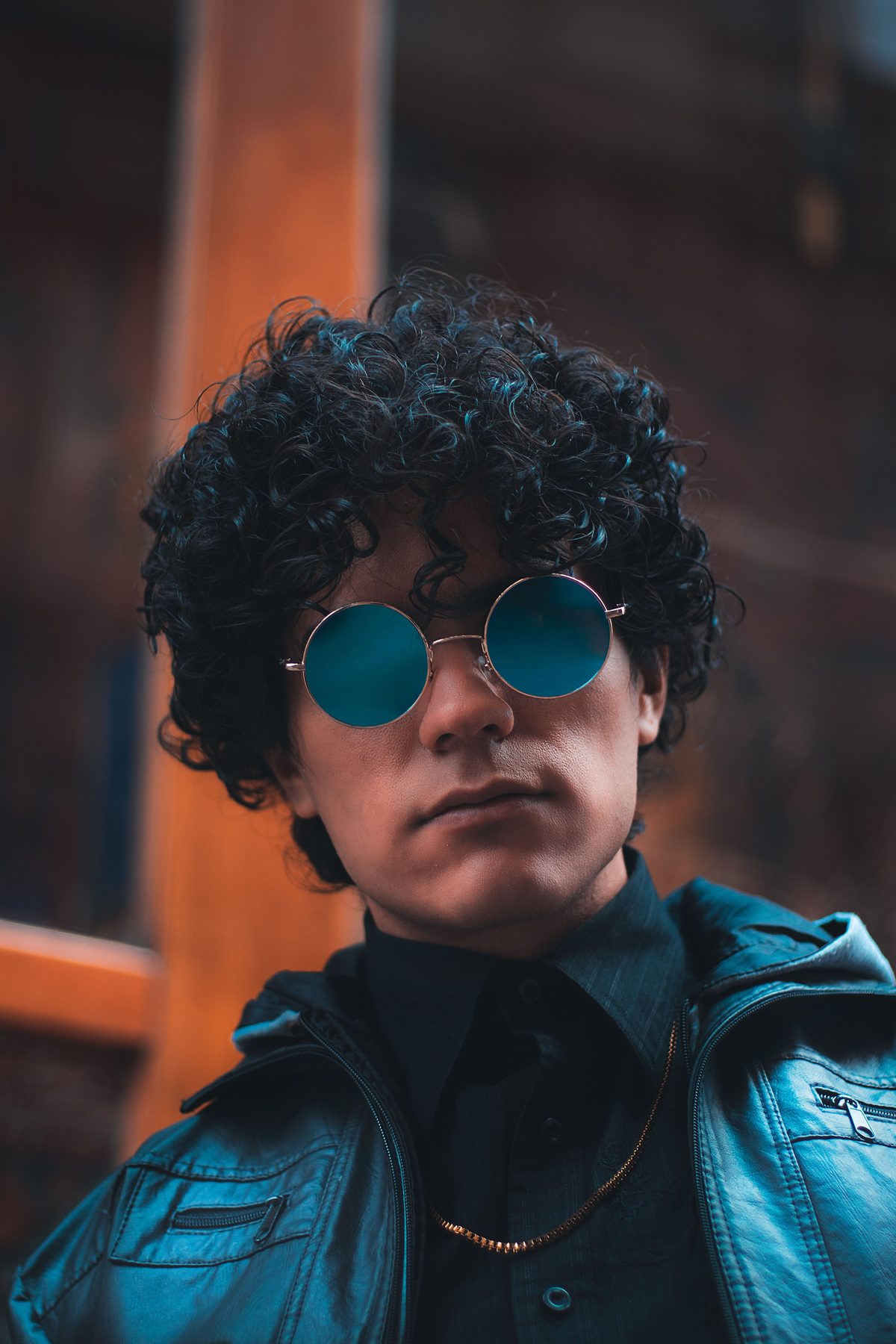 Curly hair sunglasses hairstyle shown on a young man.