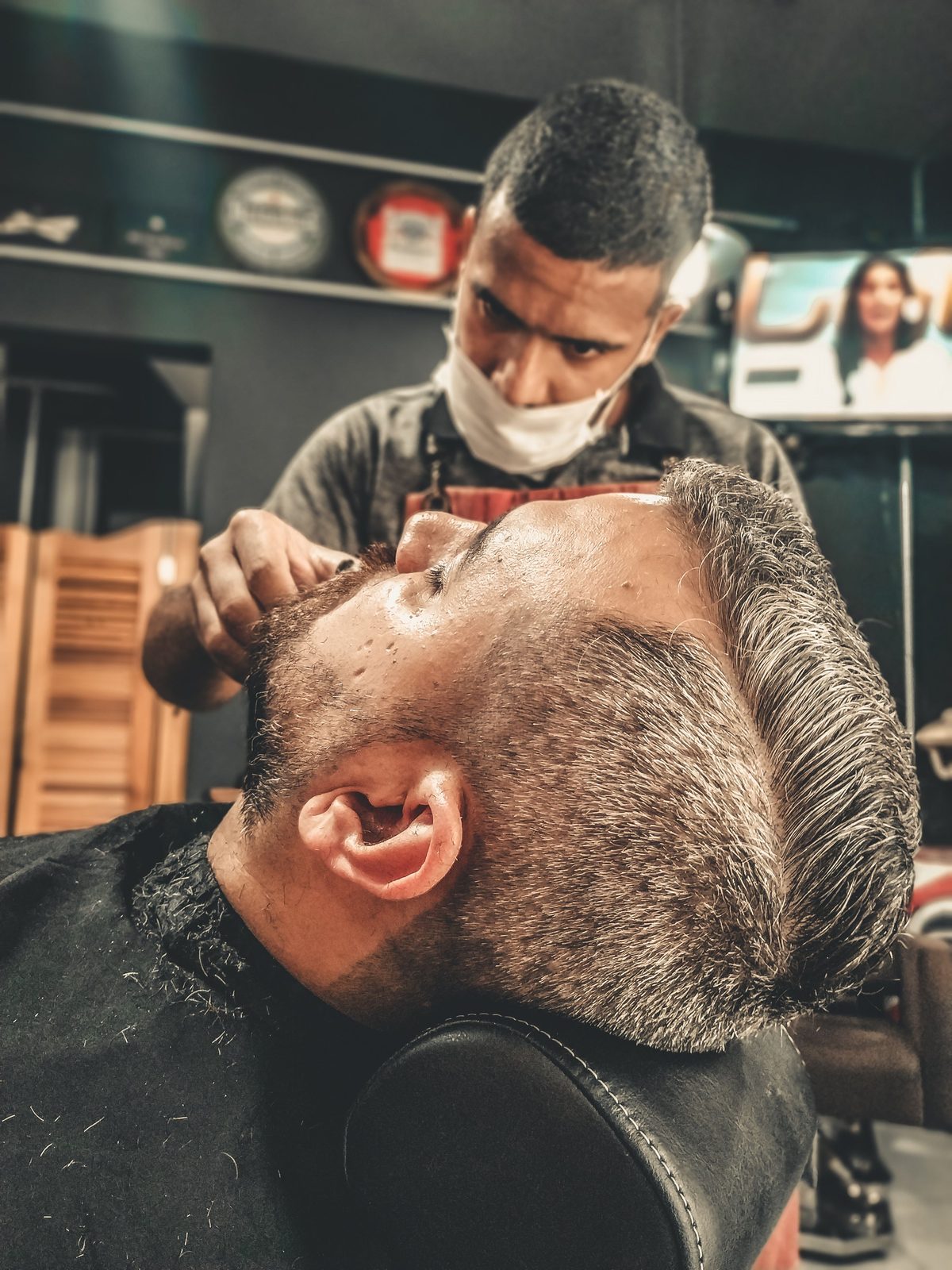 Barber grooming session hairstyle shown on a young man.