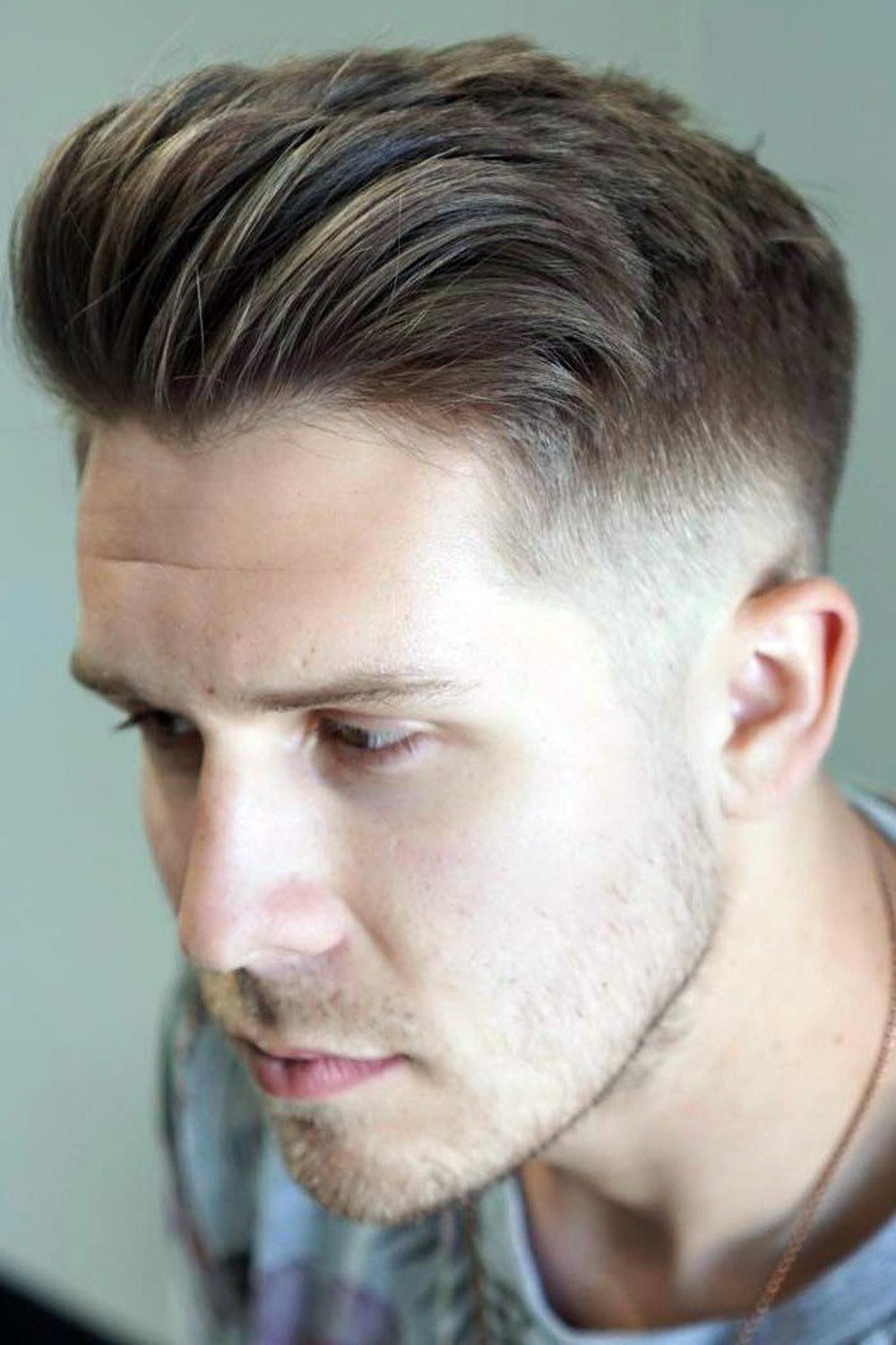 High taper fade with a relaxed textured quiff pushed up at the front