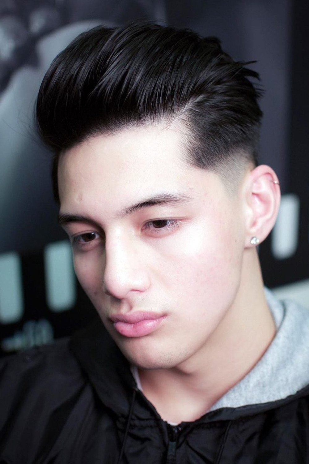 High taper fade with longer top slicked straight back, polished finish
