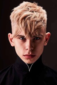 Teen boy with a bleached textured fringe haircut in a studio portrait