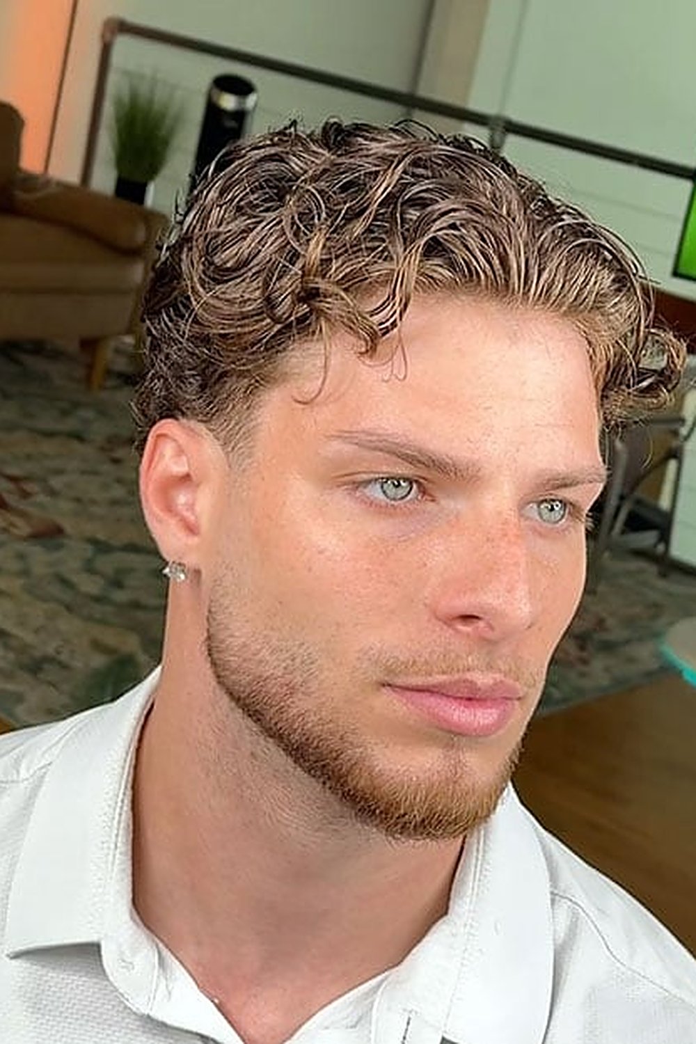 Man with wavy 90s-style curtains and a low taper — middle-parted waves with clean tapered sides