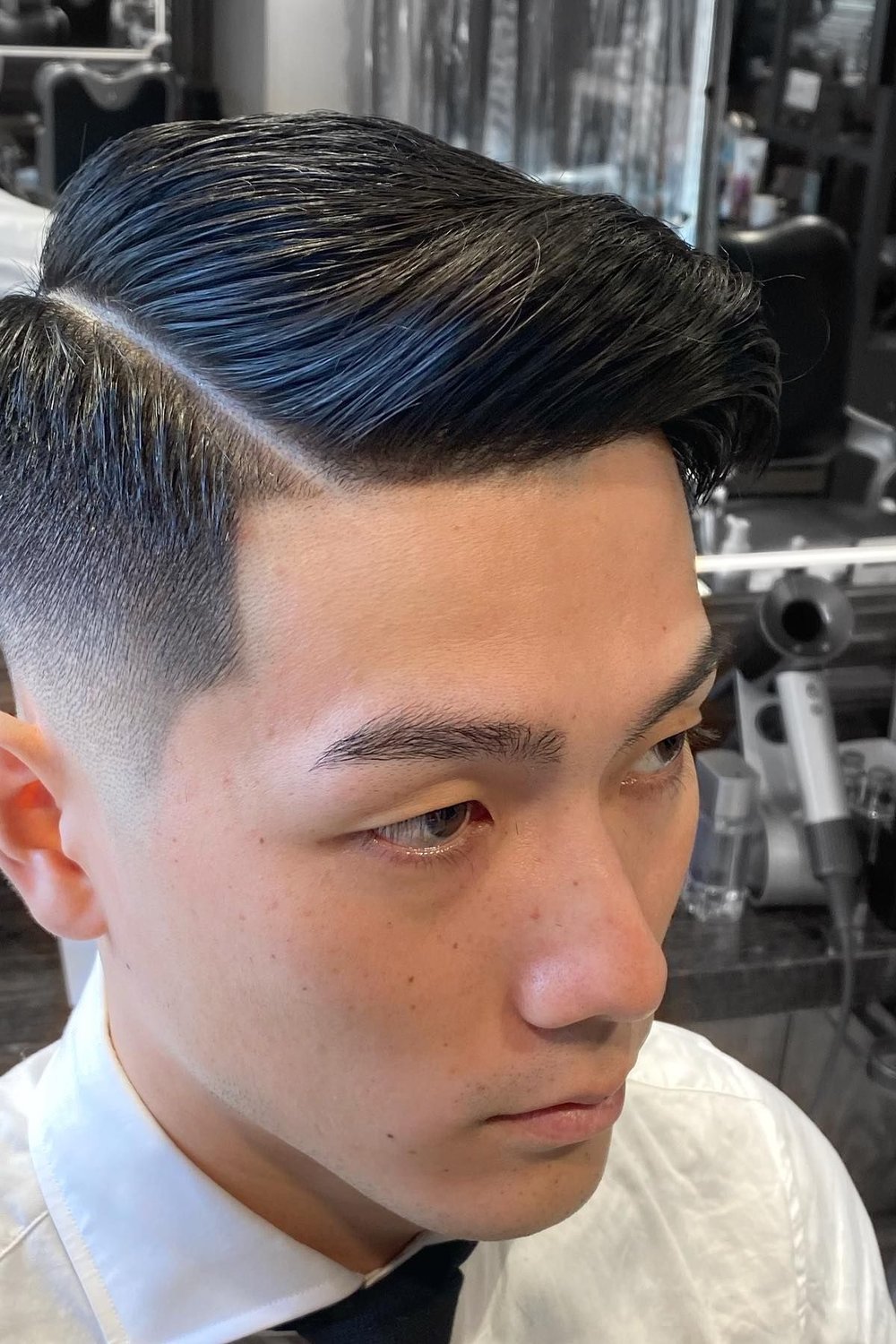 Man in a white shirt and tie with a mid fade and neatly combed side sweep