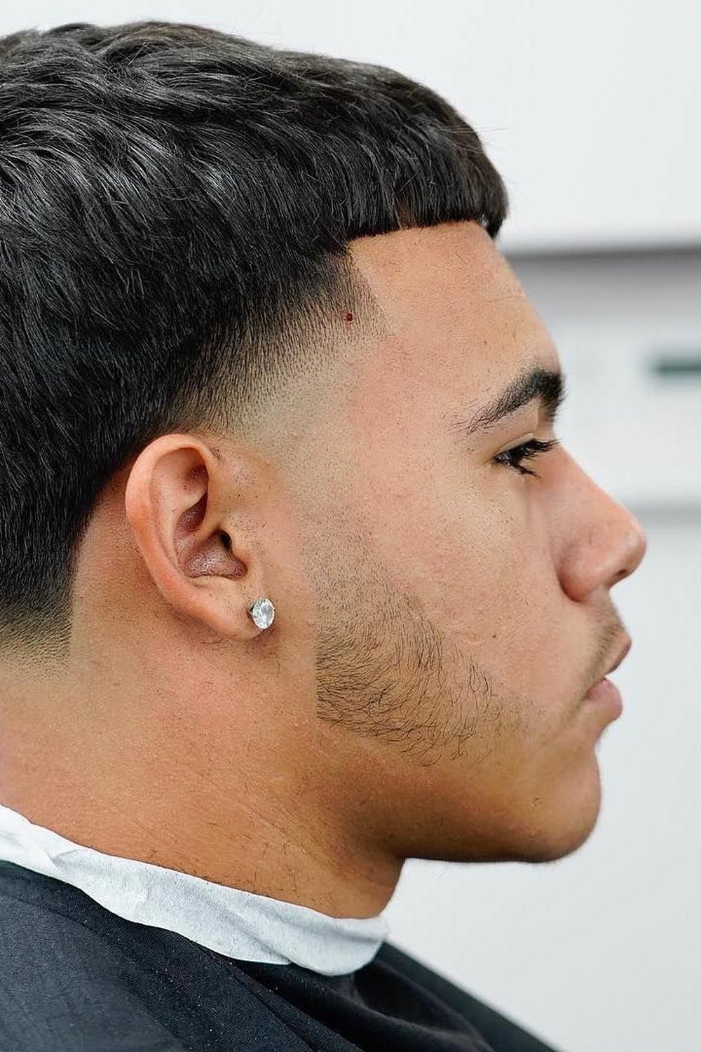 Side profile of a classic mid taper edgar with a blunt fringe and blended taper