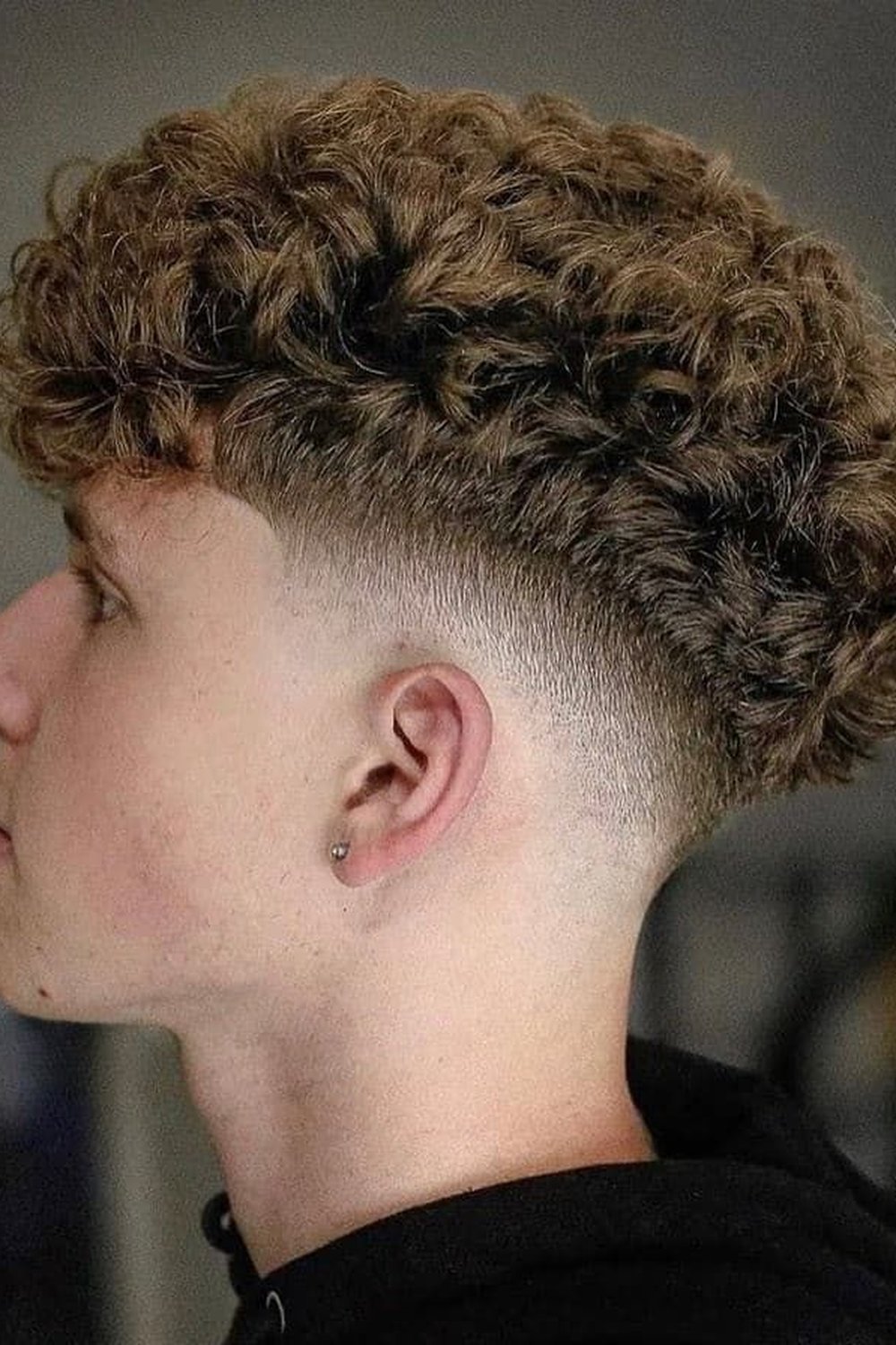Wavy edgar haircut with light-brown waves and a mid taper, side view