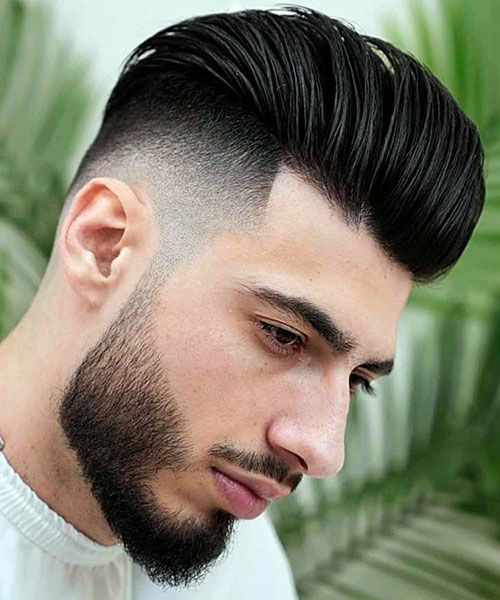 Man with slicked back hair and a burst fade undercut style