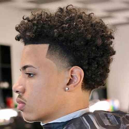 Tight curls retained over a clearly visible curved fade zone.