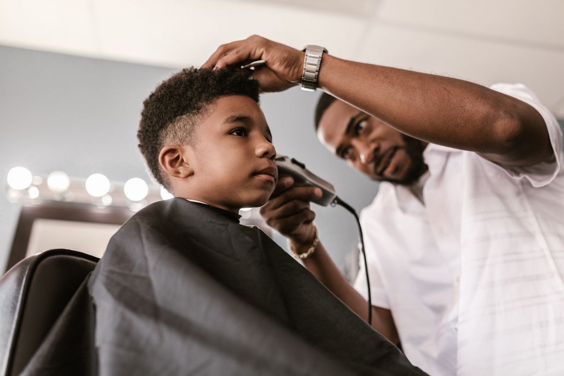 Barber using an electric razor during a haircut