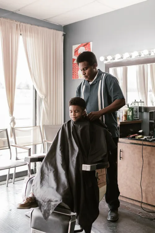 Boy wearing a cape in a hair salon