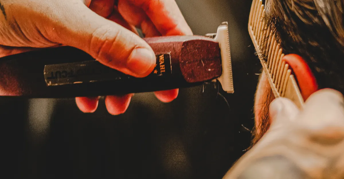 Hairstylist combing and trimming a client’s hair
