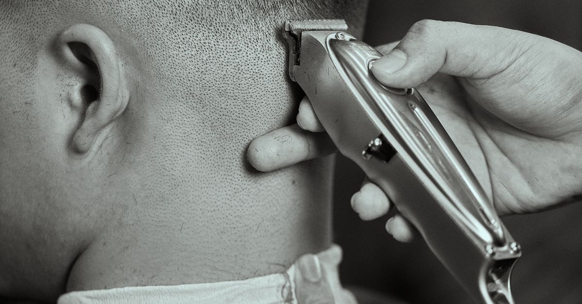 Hands refining a haircut with an electric trimmer