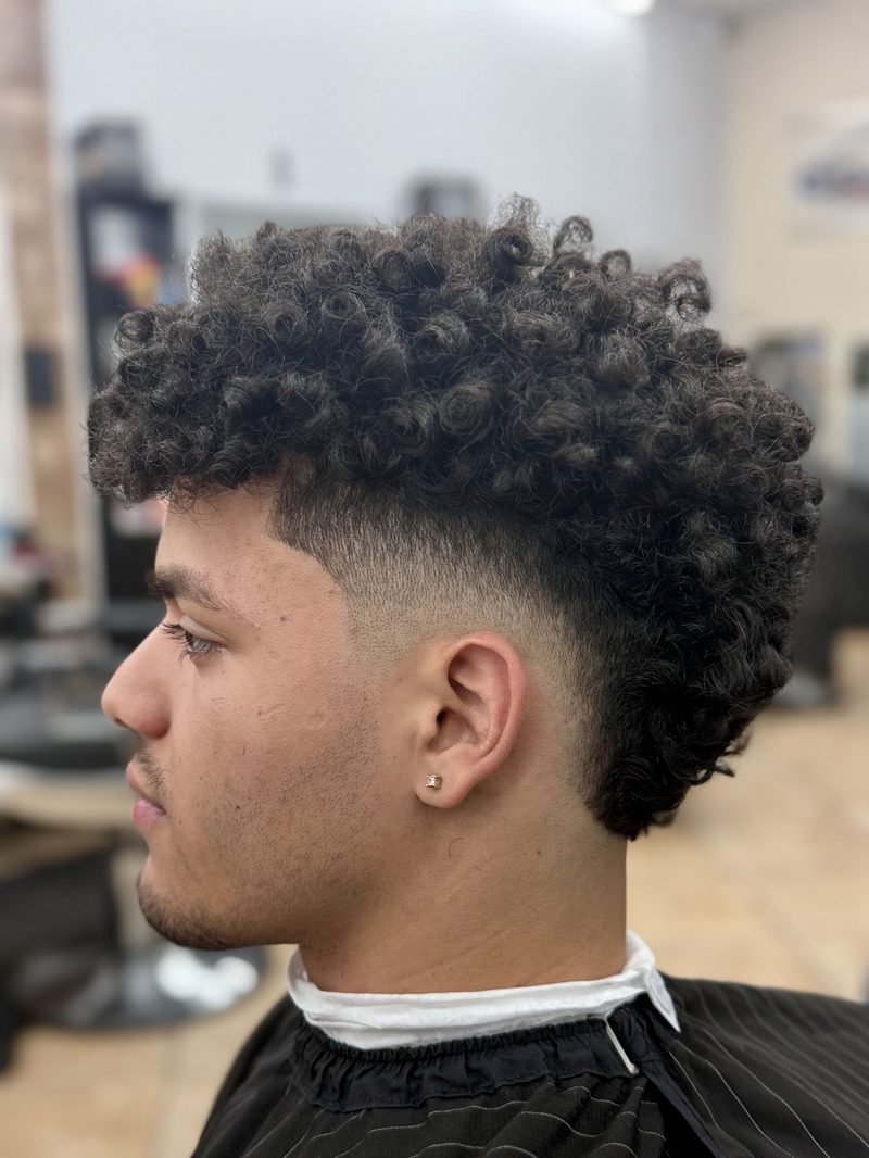 Barber refining a fade haircut in the chair.