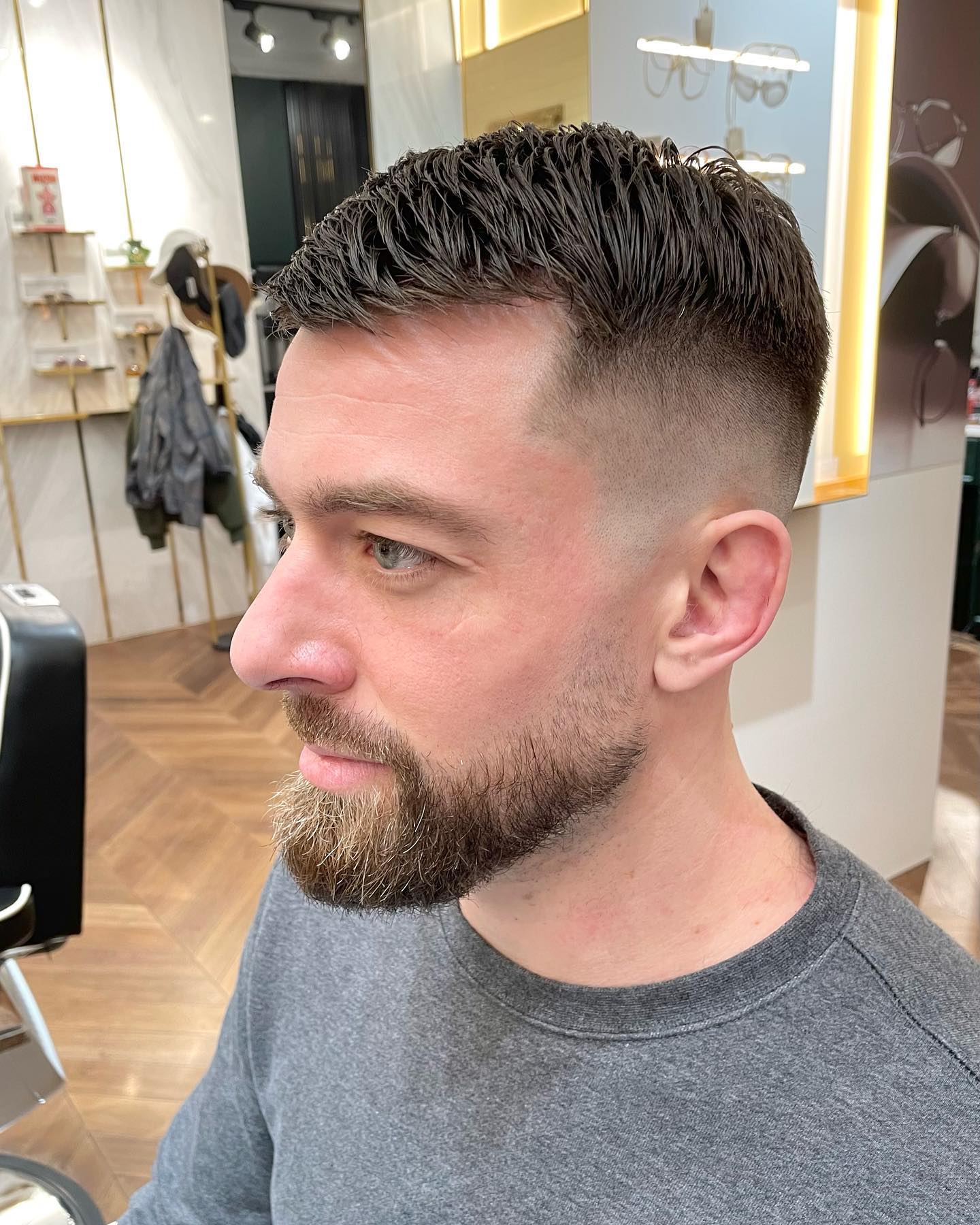 Military high-and-tight with a temple fade at the corner.